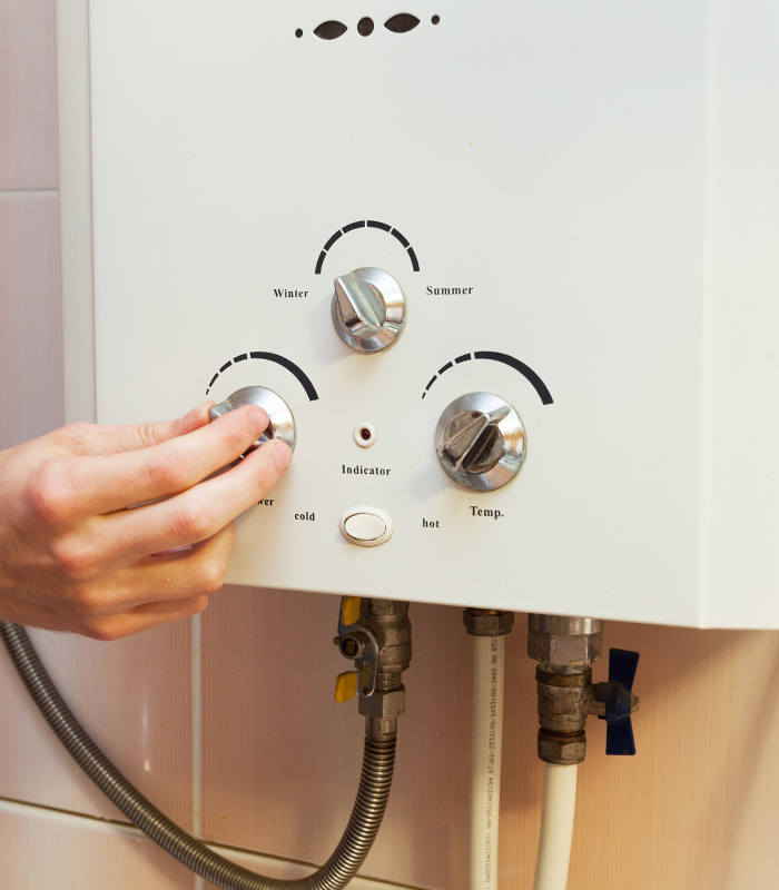 man hand close up adjusting water heater temperature peyton co